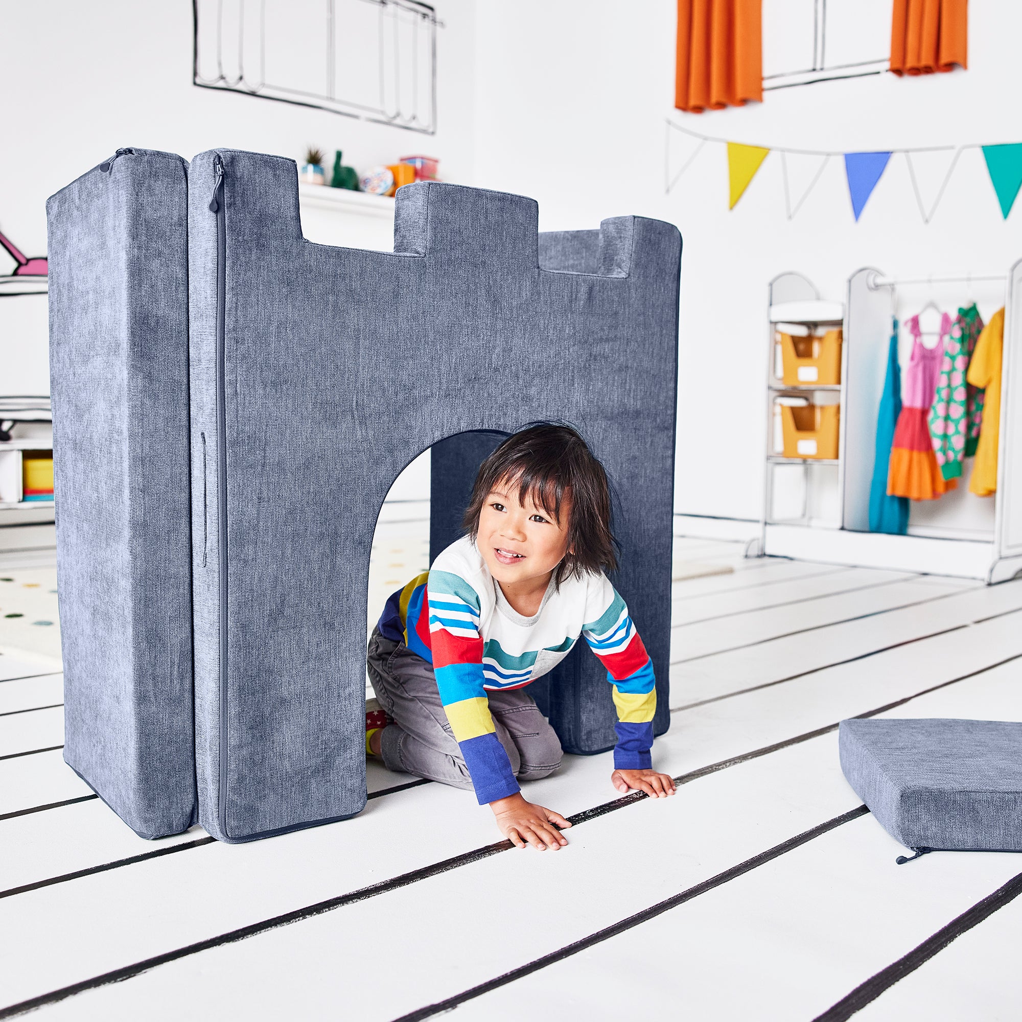 Boy crawling through the arch of the hinged doorway piece of the Yourigami Kids Play Castle in blue-lagoon color
