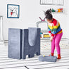 Girl preparing to hit a golf ball off the drawbridge piece and through the turrets of the upturned doorway piece of the Yourigami Kids Play Castle in blue-lagoon color 