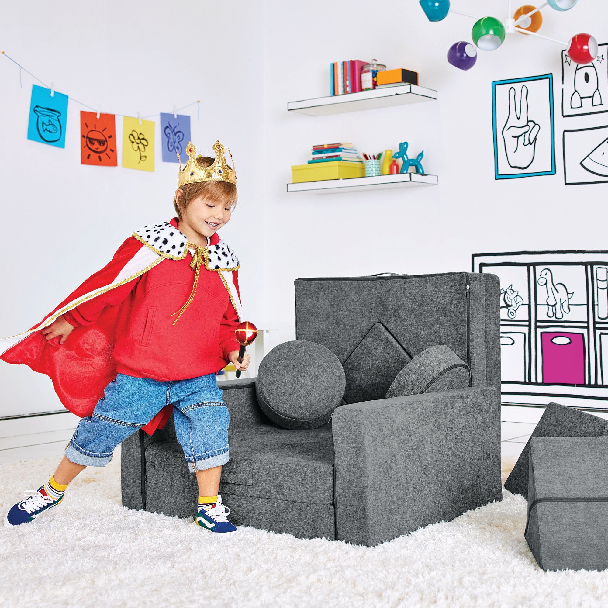 Boy dressed as a king playing by the Royal Throne configuration of the Yourigami Kids Play Fort in fossil-gray color