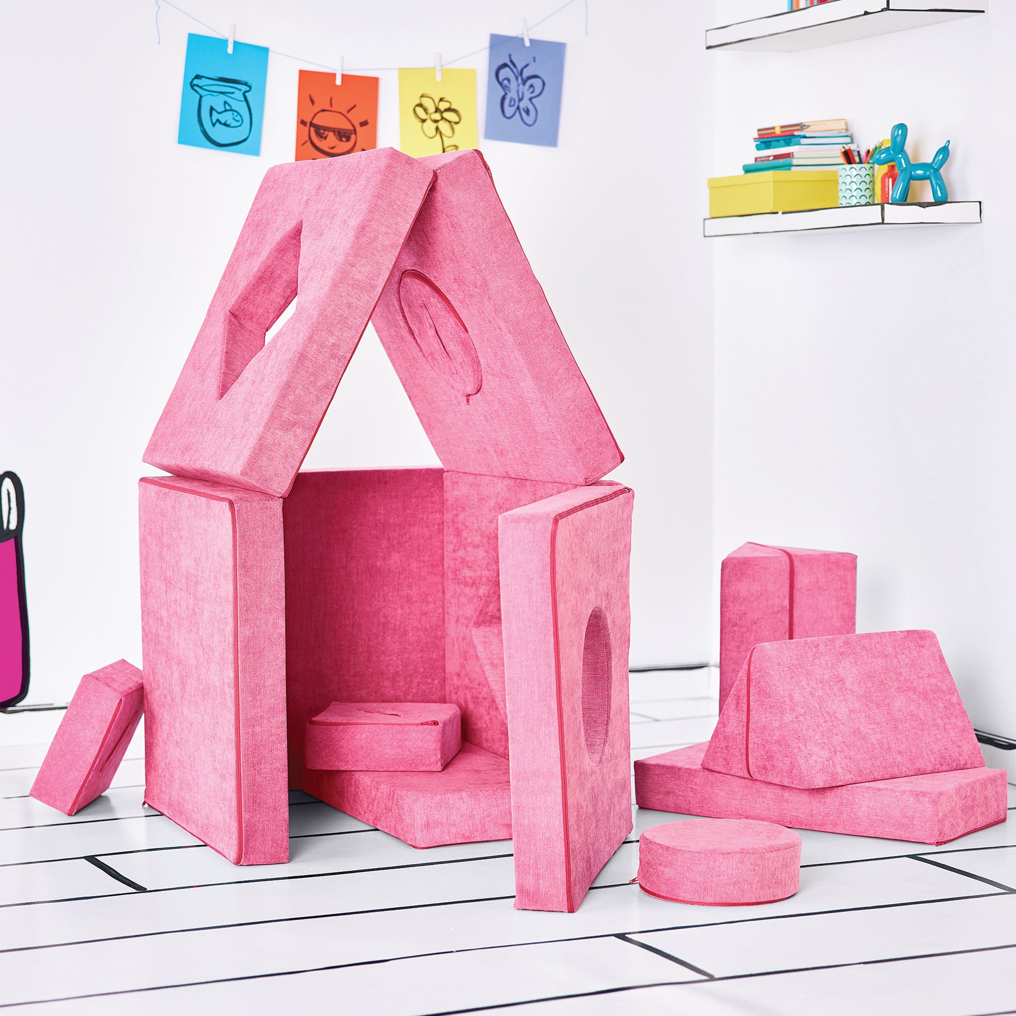 Side-view of the twelve modular pieces of the Yourigami Kids Play Fort in himalayan-pink color formed to create the Home Base configuration